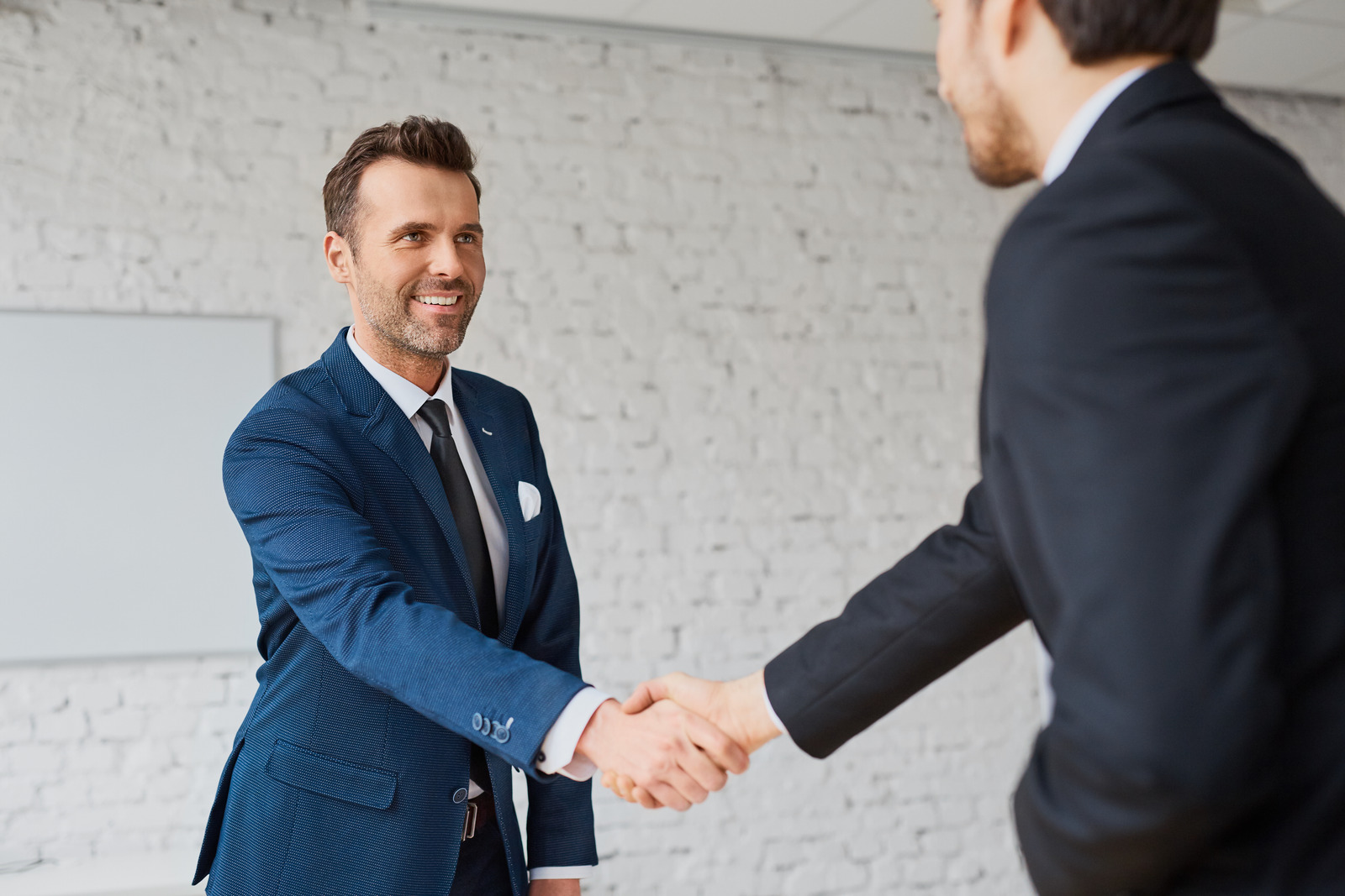 Businessmen handshaking after successful business meeting, negotiation