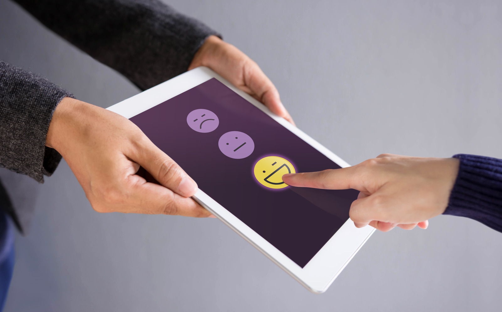 Customer Experience Concept. Happy Client Pressing a Smiley Face Sign on Digital Tablet for Online Satisfaction Survey